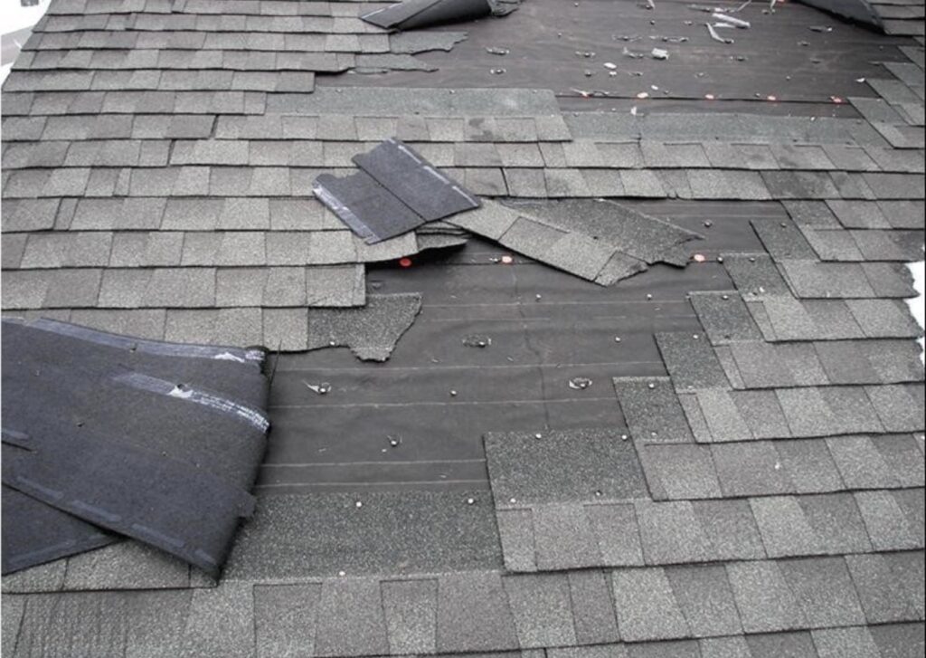 Damaged roof shingles and underlayment