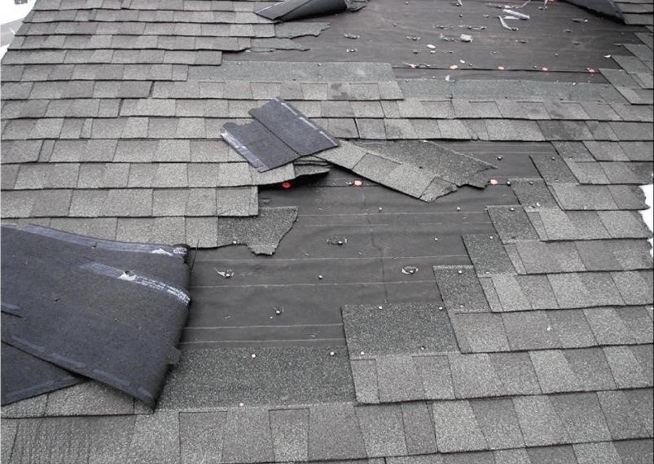 Damaged roof shingles and underlayment